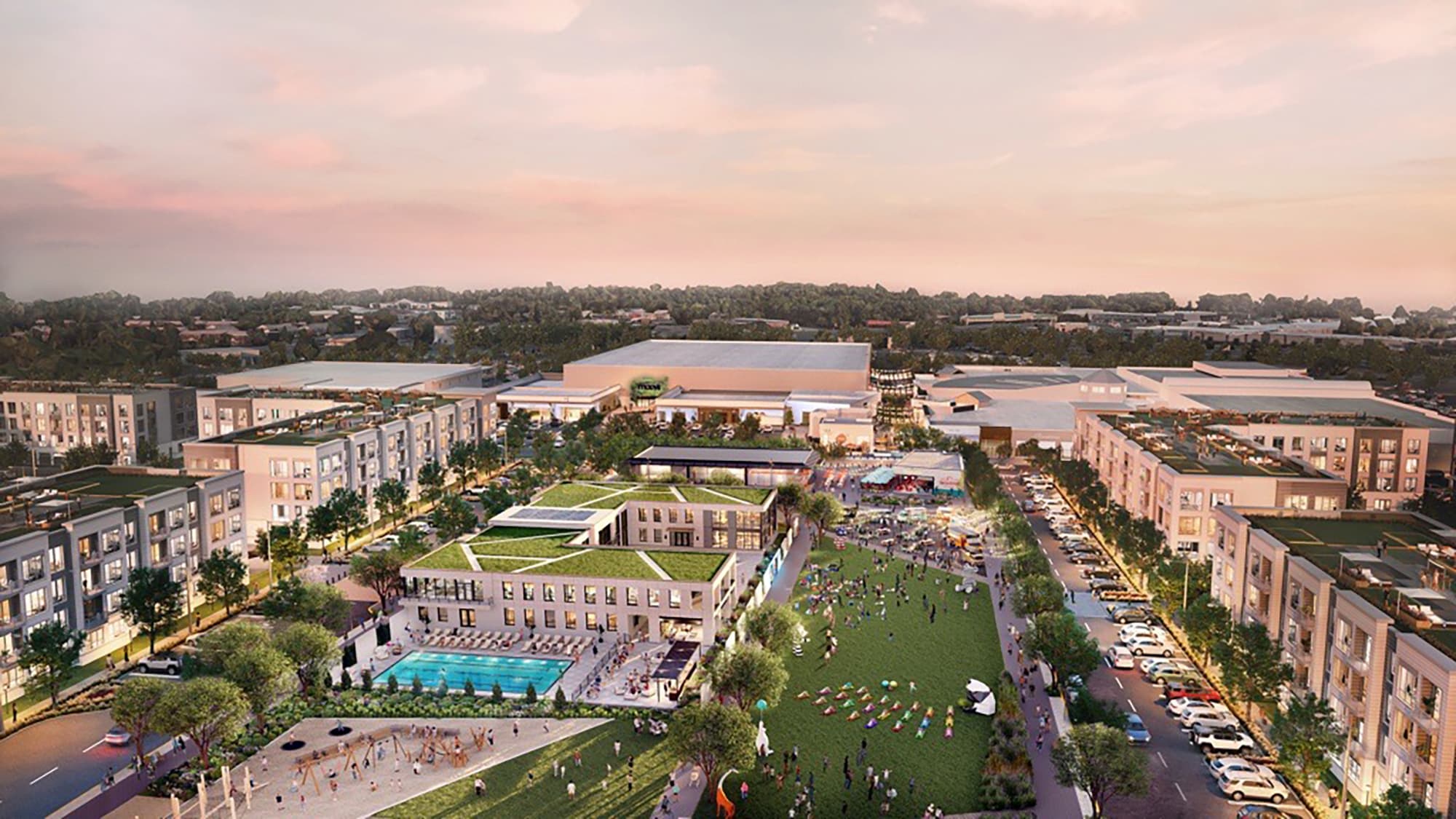 An aerial view of a large outdoor space with a pool, parking lot, lawn, and sports courts surrounded by luxury apartment buildings.